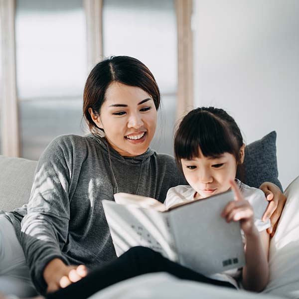 Mother reading book to little daughter