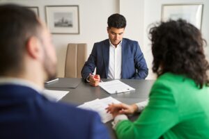 lawyer reading the documents and couple sitting in front of him