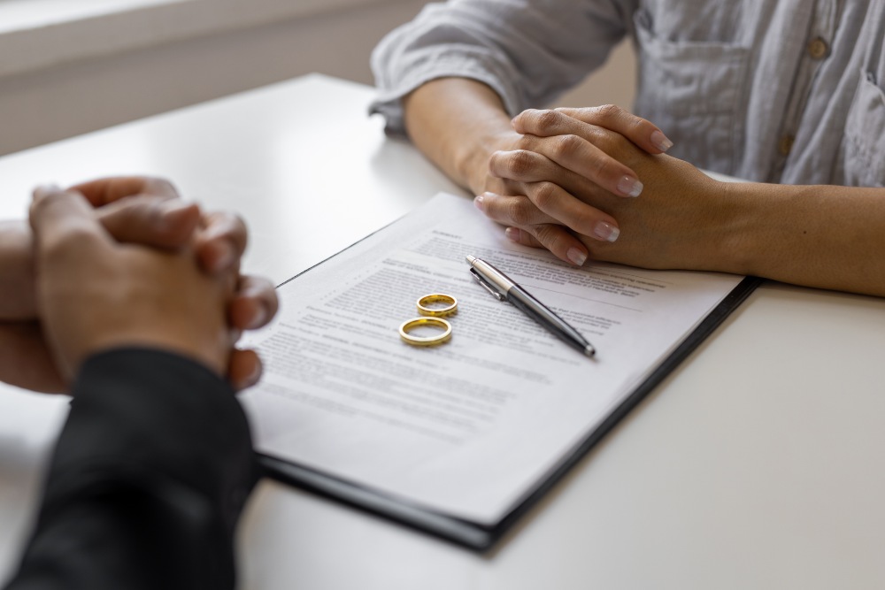 People reviewing divorce paperwork with wedding rings during a Florida family law consultation